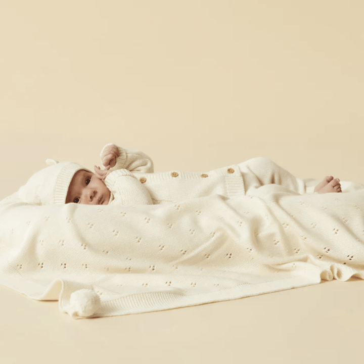Little-Baby-Lying-Down-Wearing-Wilson-And-Frenchy-Knitted-Cable-Jacket-Ecru-Naked-Baby-Eco-Boutique