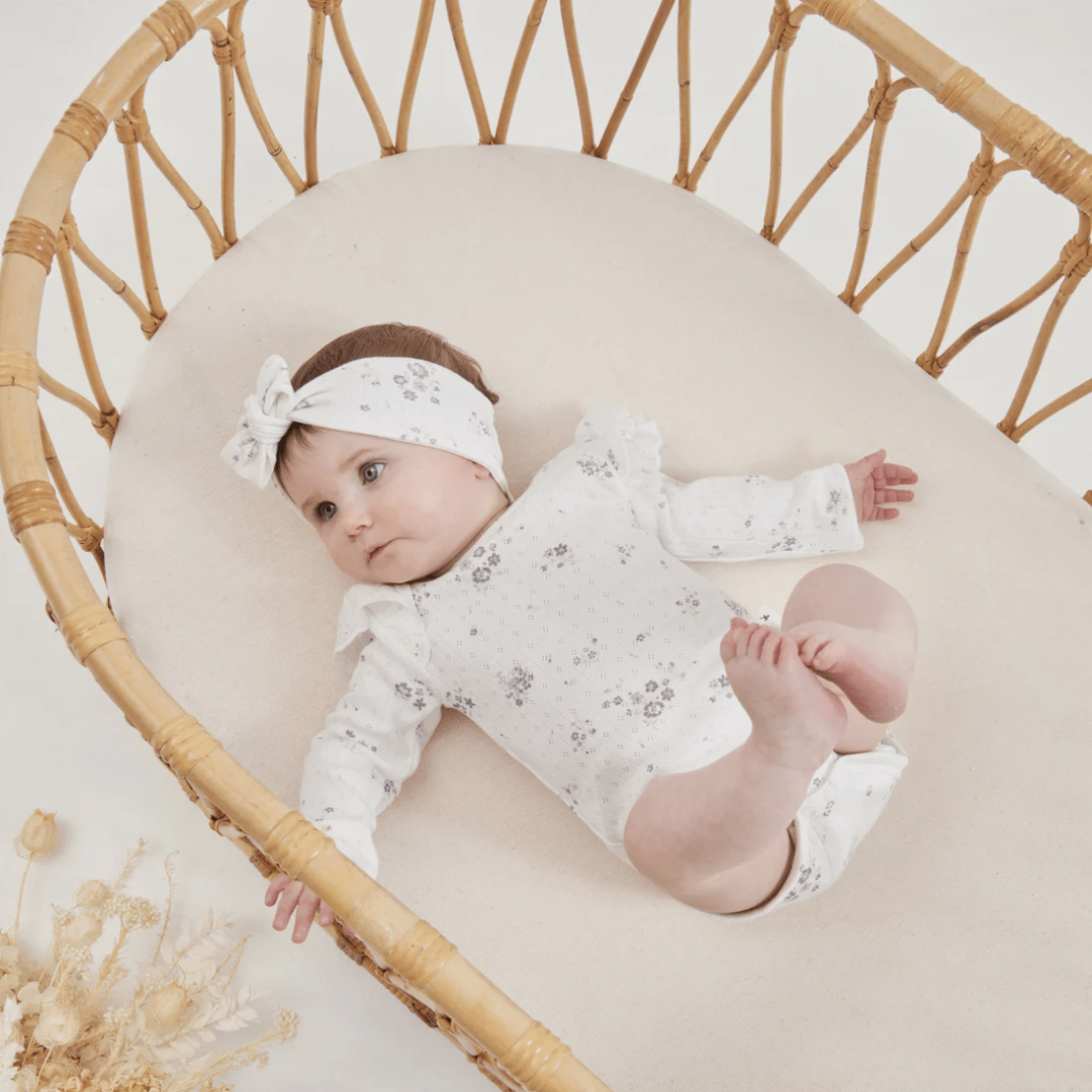 Little-Baby-Lying-In-Bassinet-Wearing-Aster-And-Oak-Organic-Grace-Floral-Flutter-Onesie-Naked-Baby-Eco-Boutique