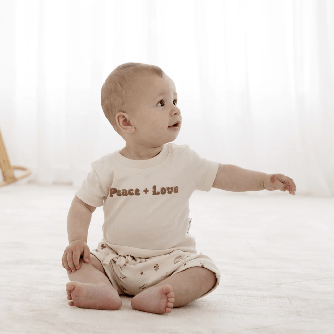 Little-Baby-Sitting-Wearing-Aster-And-Oak-Organic-Peace-And-Love-Print-Tee-Naked-Baby-Eco-Boutique