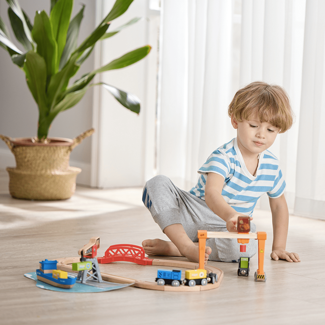Little-Boy-Playing-With-Hape-Life-And-Load-Harbour-Train-Set-Naked-Baby-Eco-Boutique