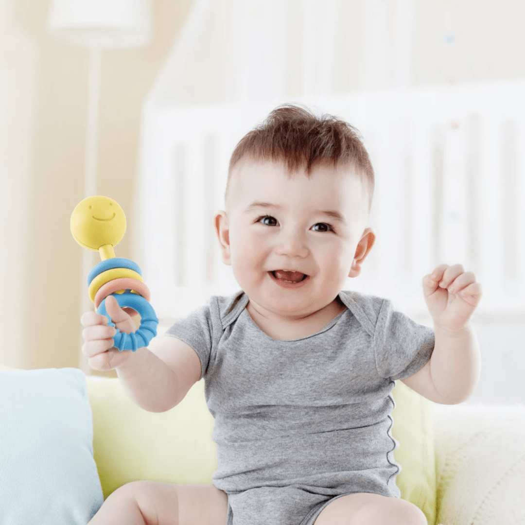 Little-Boy-Playing-With-Hape-Rattling-Rings-Naked-Baby-Eco-Boutique