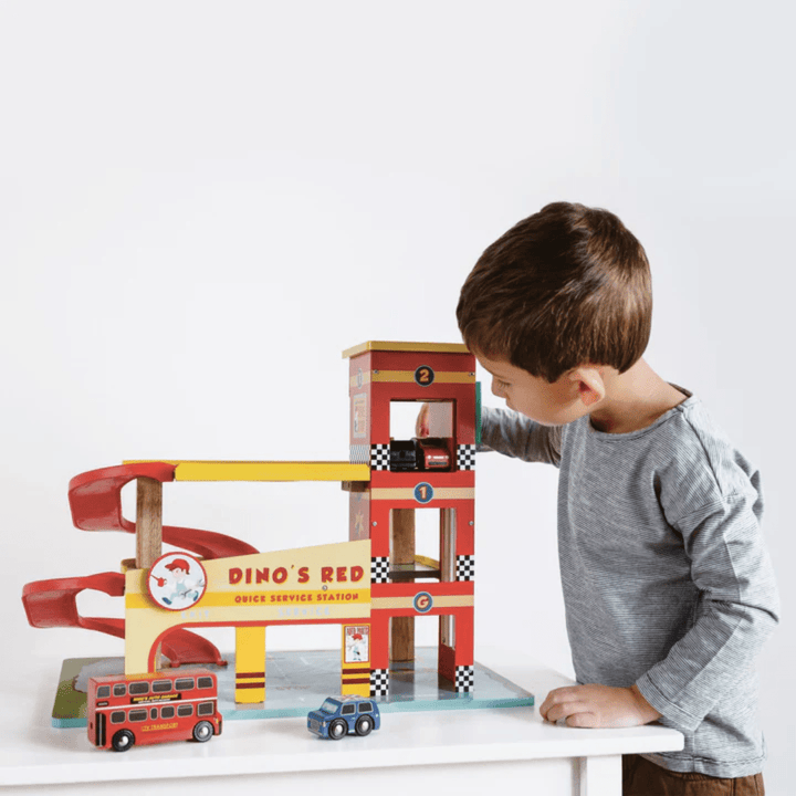 Little-Boy-Playing-With-Le-Toy-Van-Dinos-Red-Garage-Naked-Baby-Eco-Boutique