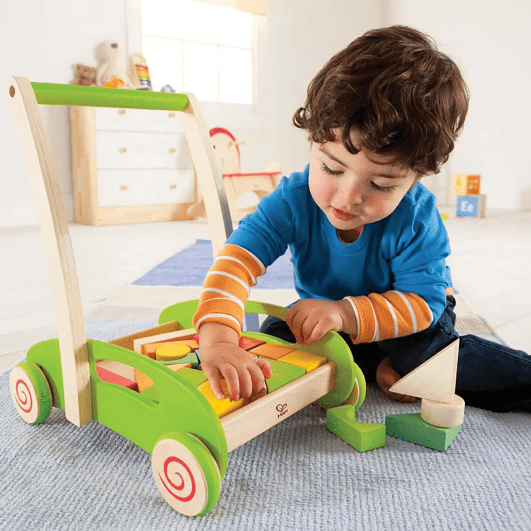 Little-Boy-Playing-with-Blocks-From-Hape-Block-and-Roll-Wagon