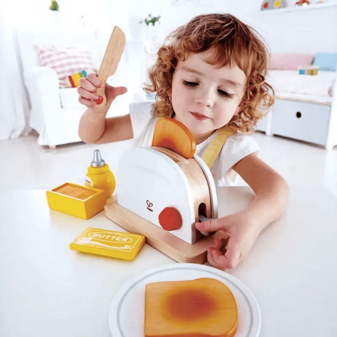 Little-Boy-Putting-Toast-In-The-Toaster-Hape-Pop-Up-Toaster-Naked-Baby-Eco-Boutique