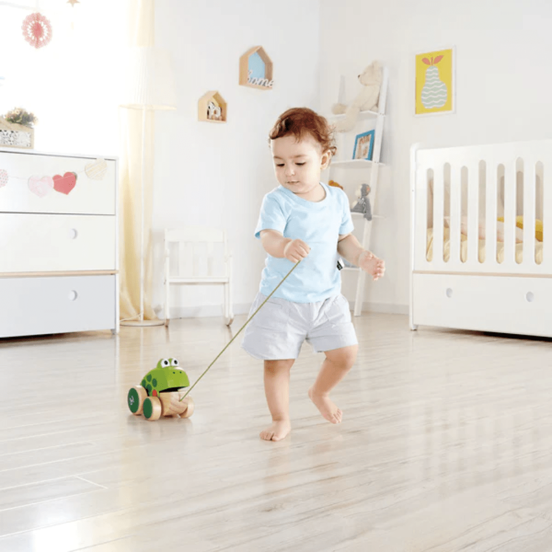 Little-Boy-Walking-And-Pulling-Along-Hape-Pull-Along-Toy-Frog-Naked-Baby-Eco-Boutique