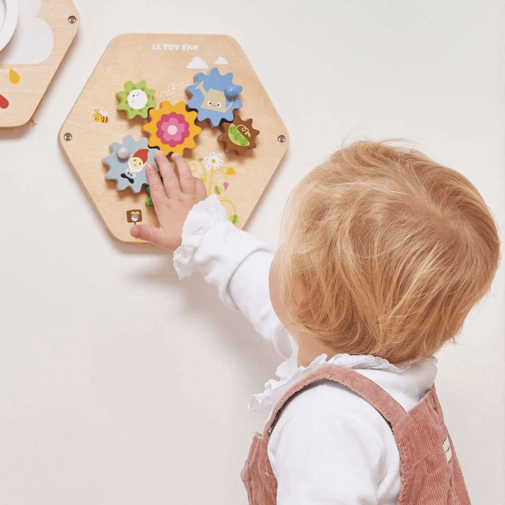 Little-Girl-Playing-WIth-Wall-Mounted-Le-Toy-Van-Activity-Tiles-Gears-Naked-Baby-Eco-Boutique