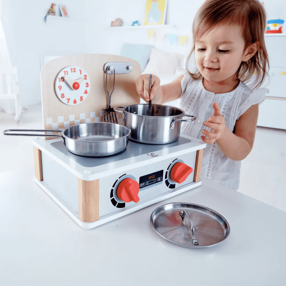 Little-Girl-Playing-With-Hape-2-In-1-Kitchen-And-Grill-Set-Naked-Baby-Eco-Boutique