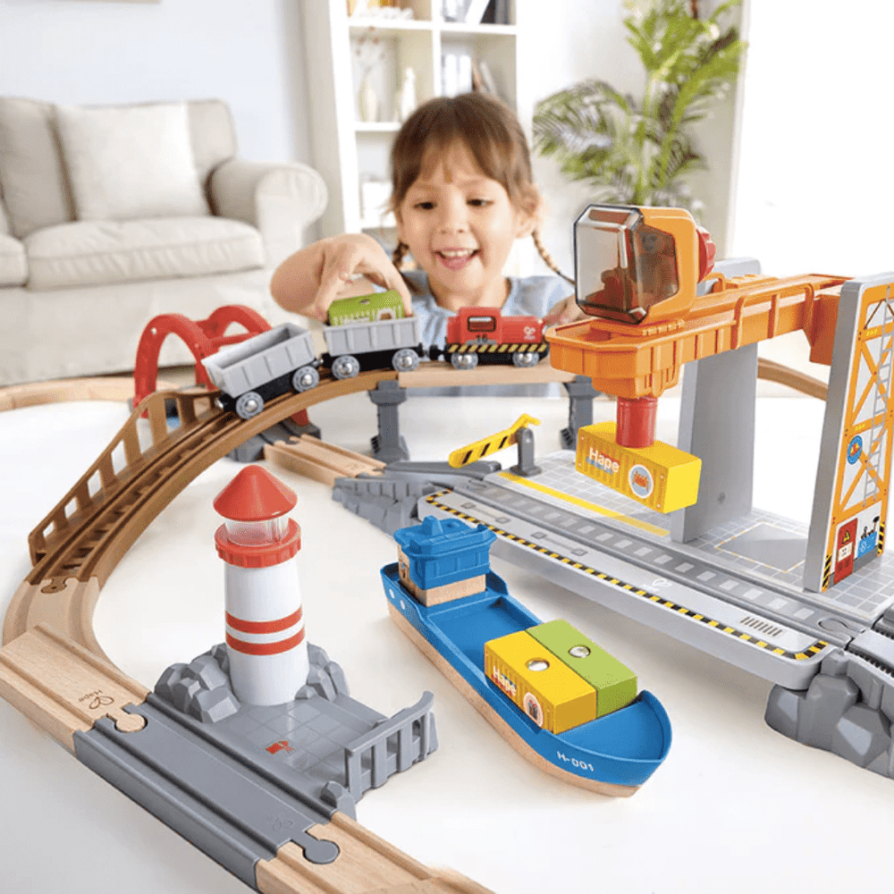 Little-Girl-Playing-With-Hape-Sea-And-Rail0Cargo-Transportation-Set-Naked-Baby-Eco-Boutique