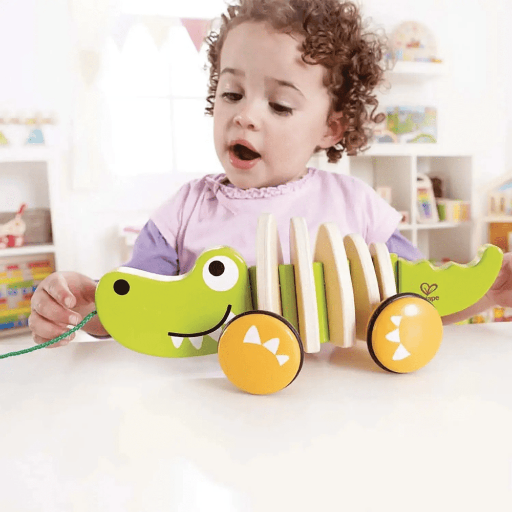 Little-Girl-Playing-With-Hape-Walk-A-Long-Croc-Naked-Baby-Eco-Boutique