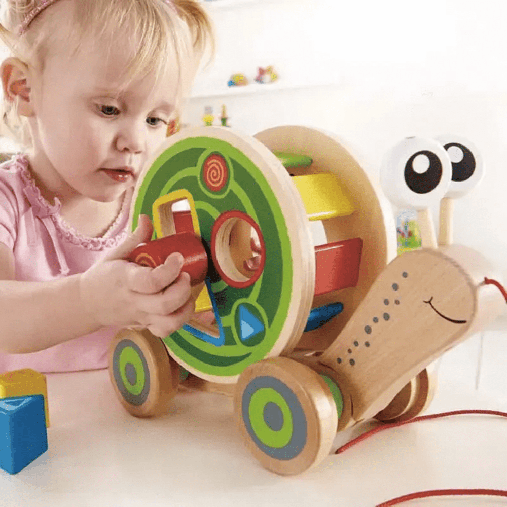 Little-Girl-Playing-With-Hape-Walk-A-Long-Snail-Naked-Baby-Eco-Boutique