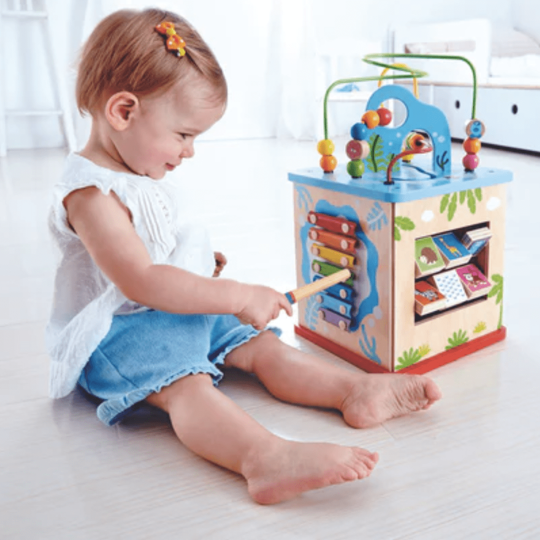 Little-Girl-Playing-With-Xylophone-On-Hape-Multi-Functional-Play-Cube-Naked-Baby-Eco-Boutique