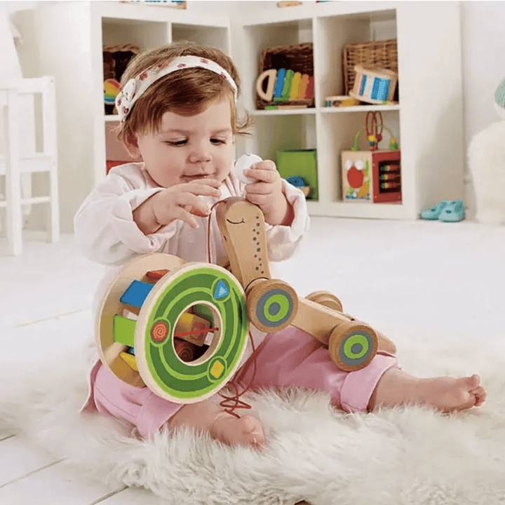 Little-Girl-Sitting-With-Hape-Walk-A-Long-Snail-Naked-Baby-Eco-Boutique
