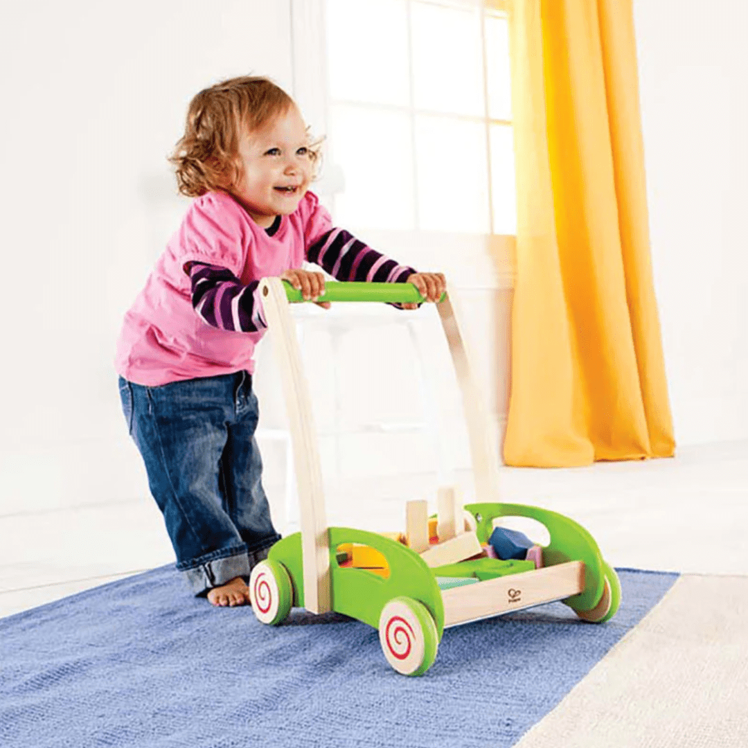 Little-Girl-Walking-With-Hape-Block-and-Roll-Wagon