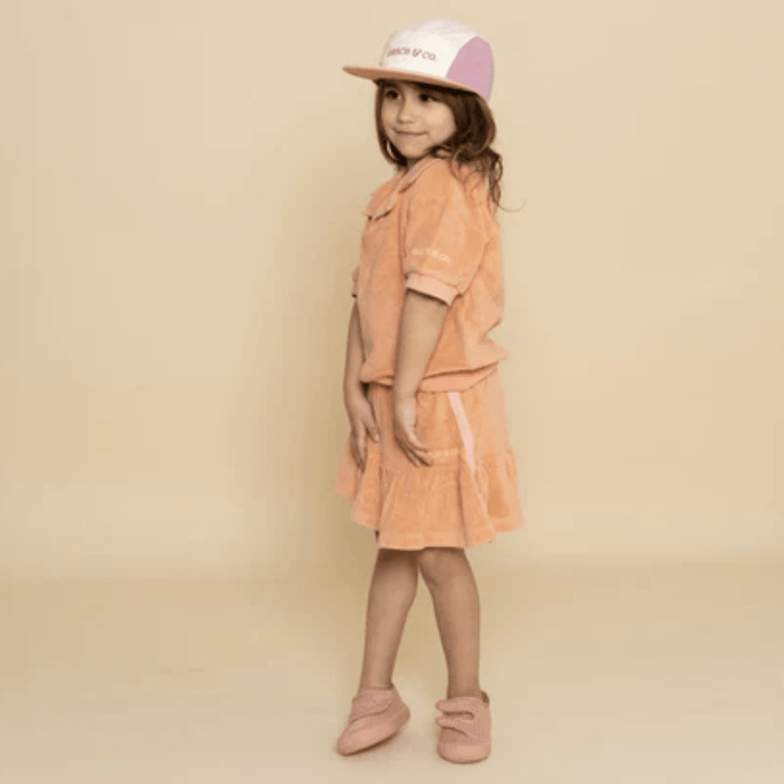 Little-Girl-Wearing-Grech-And-Co-Organic-Anti-UV-5-Panel-Hat-Blush-Bloom-Mauve-Rose-Naked-Baby-Eco-Boutique