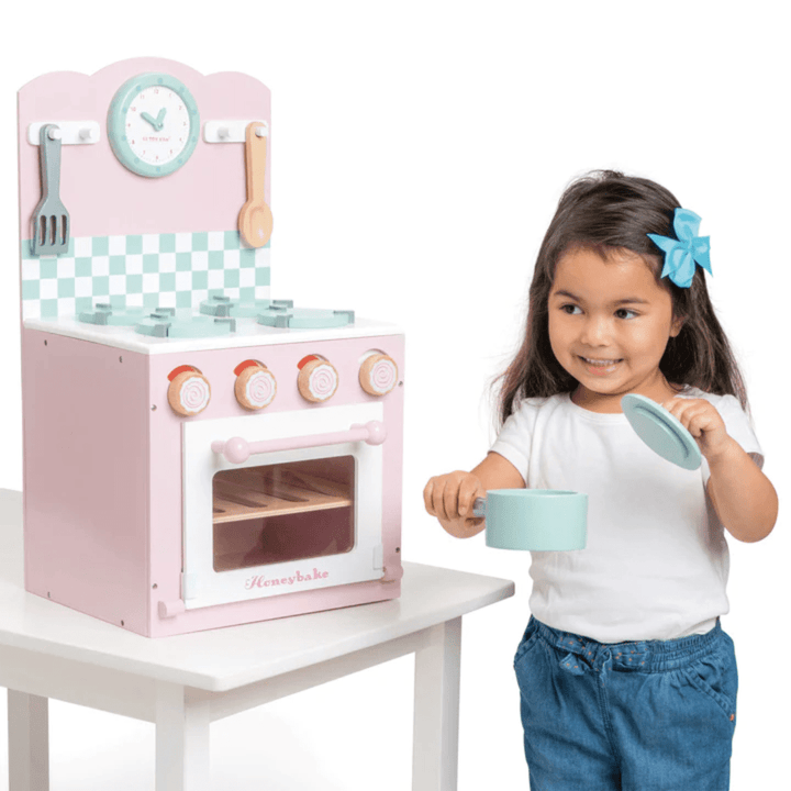 Little-Girl-With-Pot-Playing-With-Le-Toy-Van-Oven-And-Hob-Set-Naked-Baby-Eco-Boutique