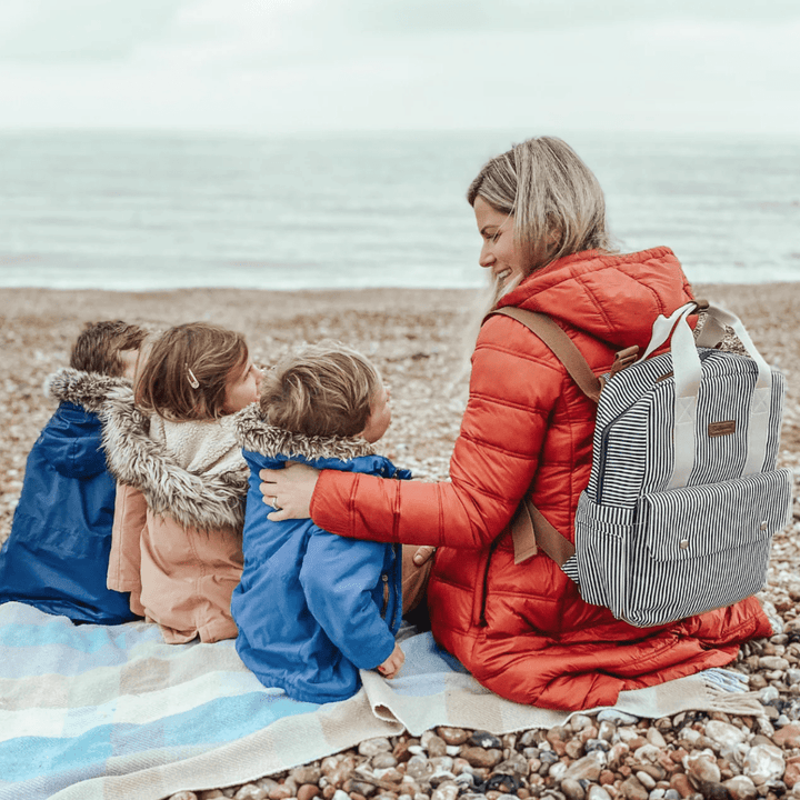 Mum-at-Beach-with-Kids-Wearing-Babymel-Georgi-Eco-Convertible-Nappy-Backpack-Navy-Stripe-Naked-Baby-Eco-Boutique