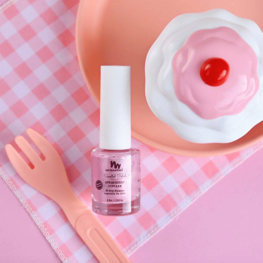 A bottle of No Nasties 20 FREE Kids Scented Nail Polish (Multiple Variants) (non-toxic ingredients) and a fork on a pink plate.