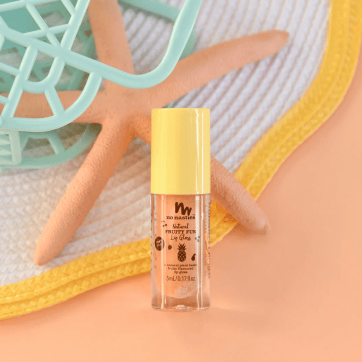 A bottle of No Nasties All-Natural Kids Lip Gloss (Multiple Variants) from No Nasties Play Makeup sitting next to a starfish, offering sun protection and beach essentials.