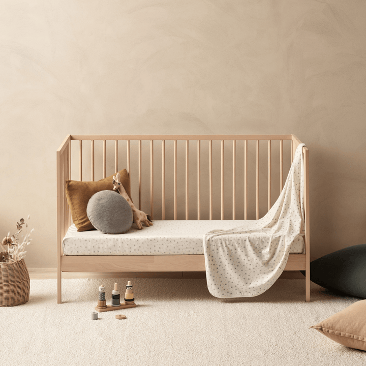 An Wilson & Frenchy Organic Cotton Cot Sheet - LUCKY LASTS - FLOAT AWAY ONLY with a blanket and a pillow, perfect as a baby shower present or for adding a cot sheet.