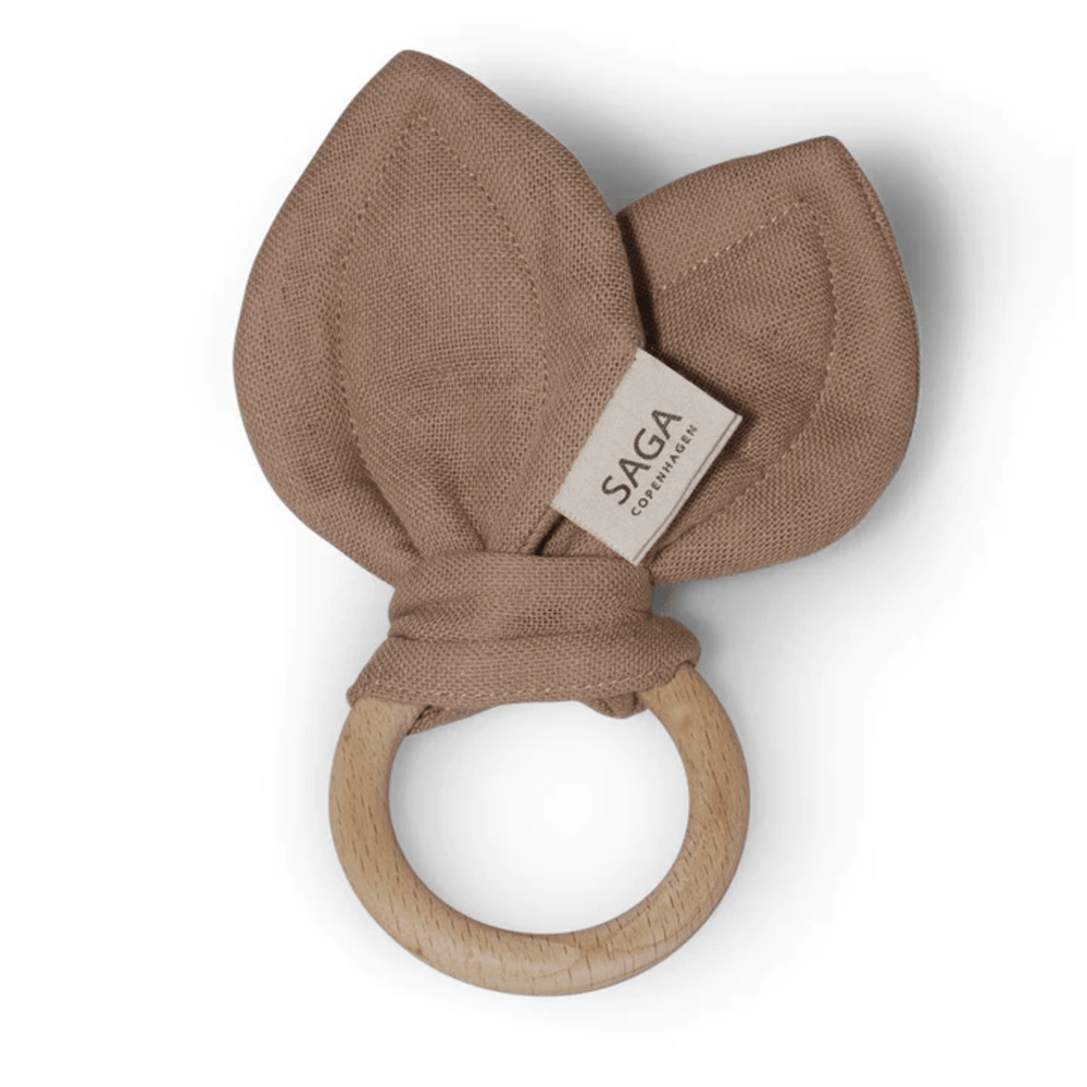 A Saga Copenhagen organic cotton teething ring made with beechwood, featuring a brown leaf on it.