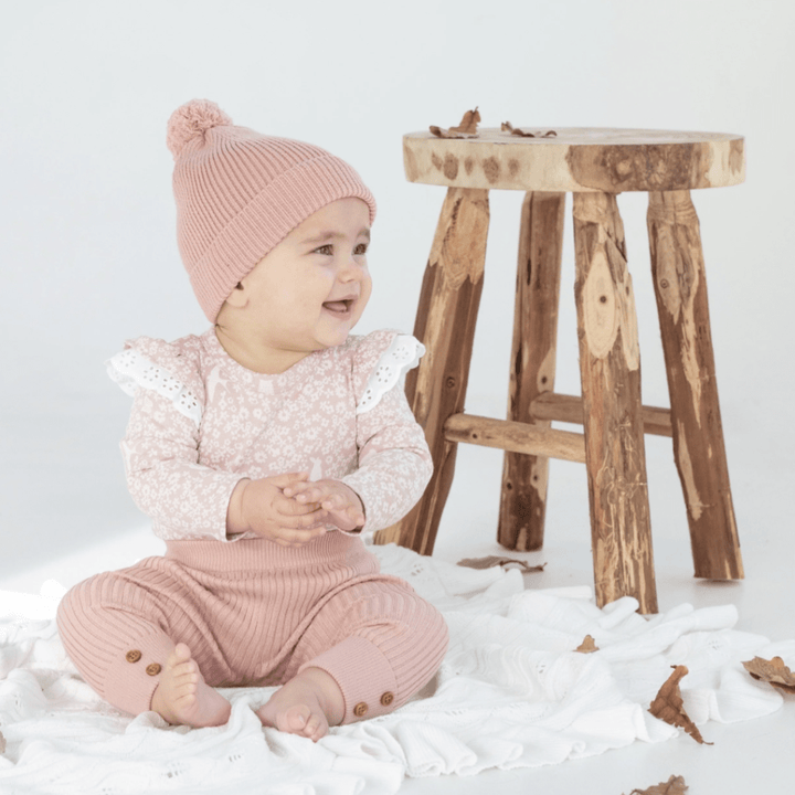 Smiling-Baby-sitting-on-Aster-and-Oak-Organic-Ruffle-Cable-Knit-Baby-Blanket-Snow-Naked-Baby-Eco-Boutique