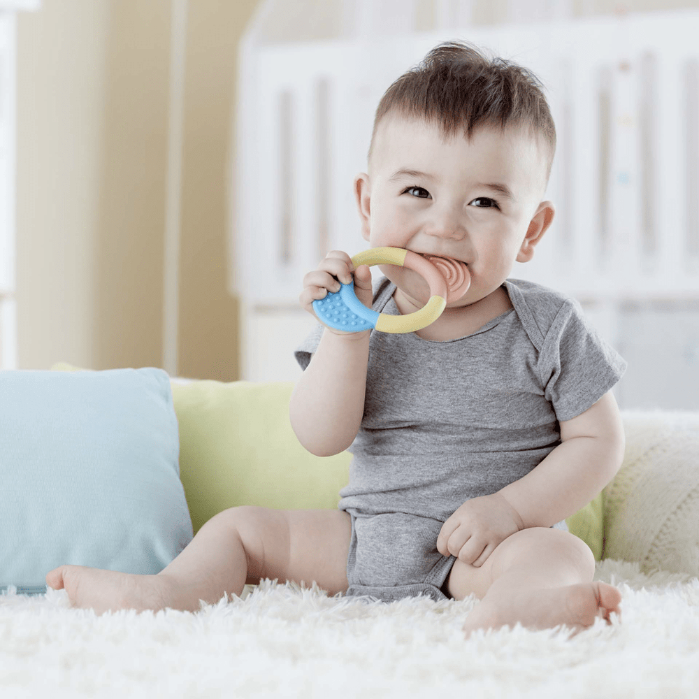 Smiling-Happy-Baby-Chewing-On-Hape-Teething-Ring-Naked-Baby-Eco-Boutique