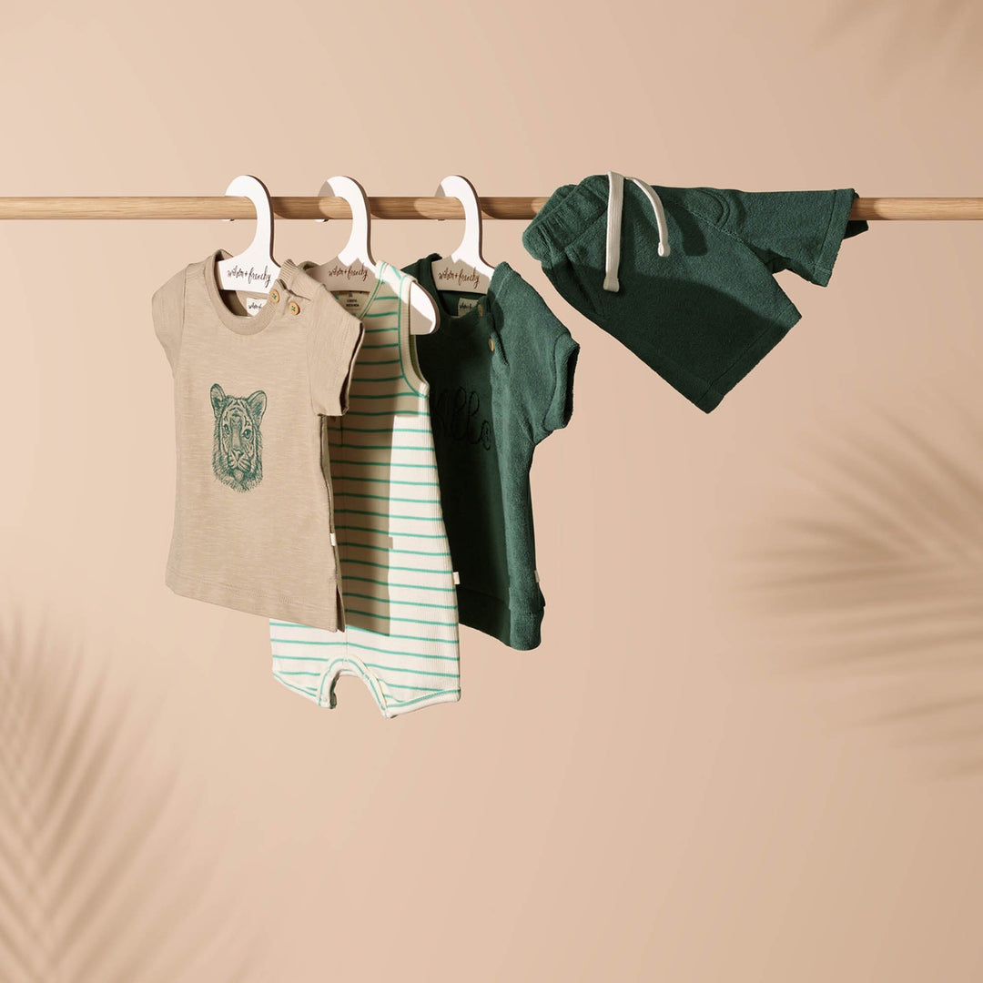 A collection of Wilson & Frenchy Leo the Lion Organic Tee baby clothes hanging on a clothesline, featuring easy dressing and organic cotton.