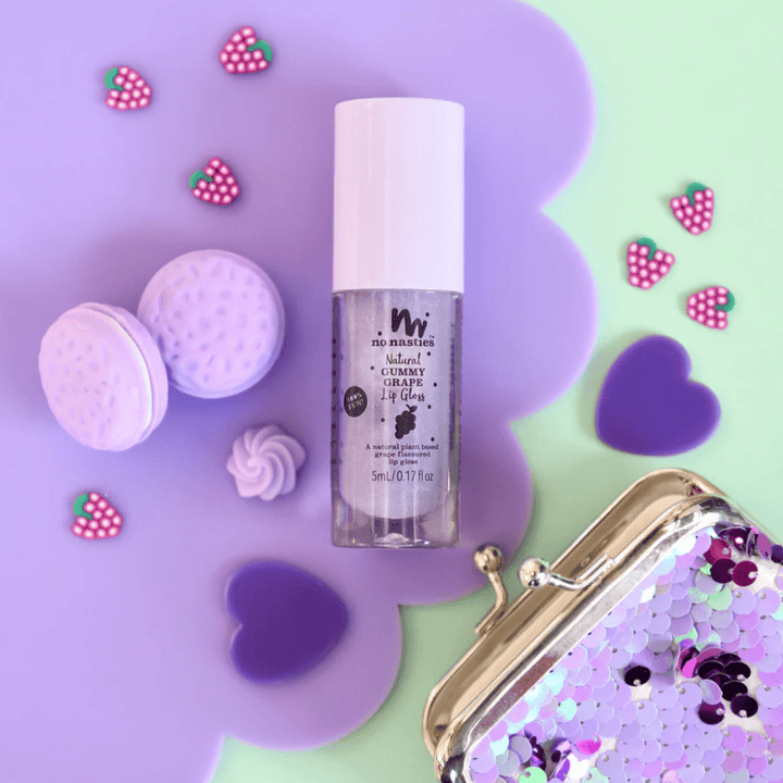 A vibrant purple background showcasing a No Nasties All-Natural Kids Lip Gloss (Multiple Variants) from the No Nasties Play Makeup brand and a nourishing lip balm.