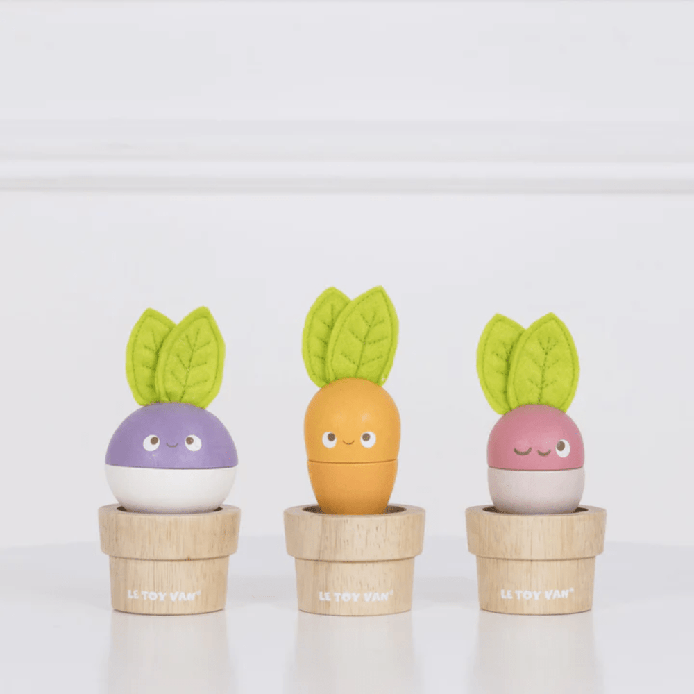 Three Le Toy Van Stacking Veggies in pots on a white table. Le Toy Van, wooden toy.