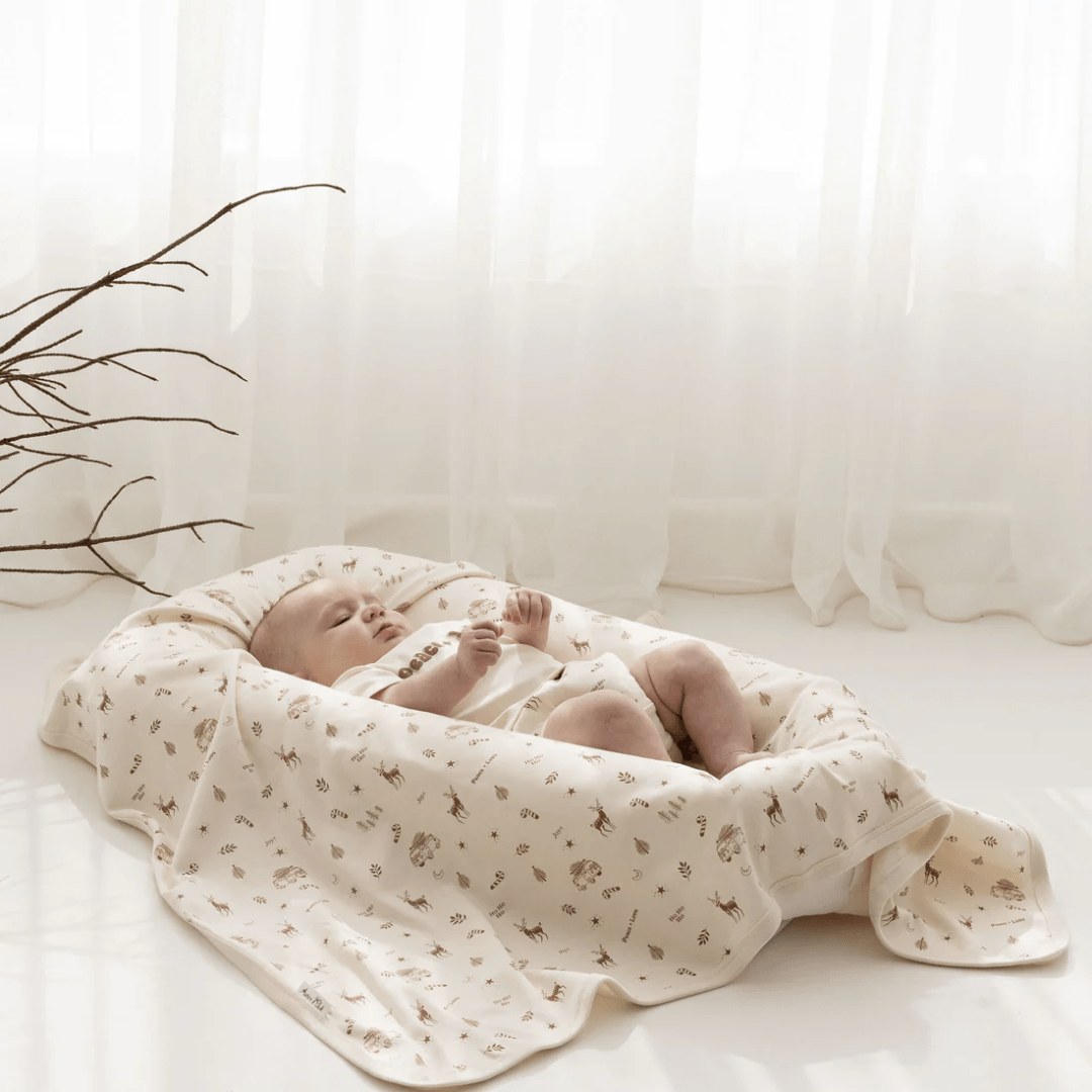 Styled-Image-Of-Little-Baby-Lying-On-Aster-And-Oak-Organic-Happy-Holidays-Baby-Swaddle-Wrap-Naked-Baby-Eco-Boutique