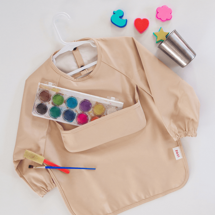 A Zazi Recycled Full-Sleeved Bib (Multiple Variants) with a set of paints and brushes.