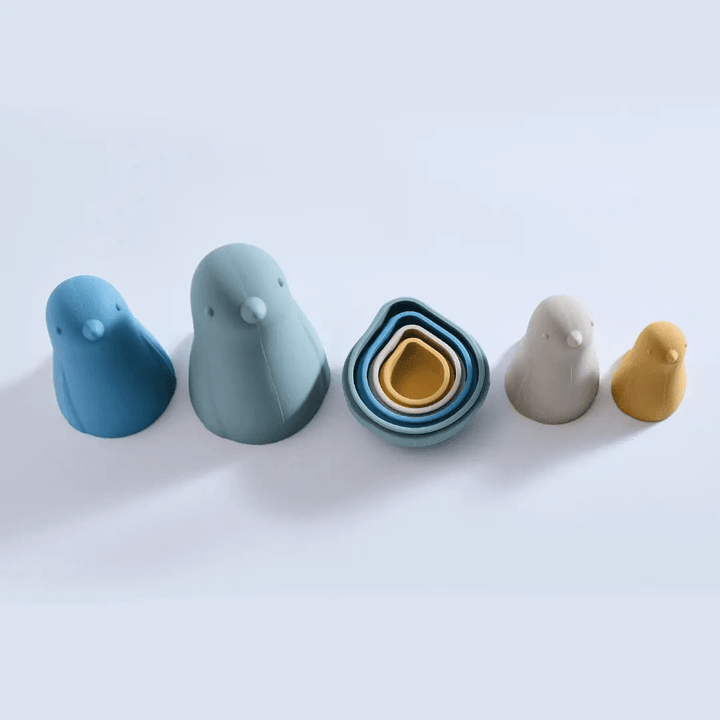A group of durable Classical Child silicone stacking dolls made of silicone in blue and yellow colors shaped like birds on a white surface.