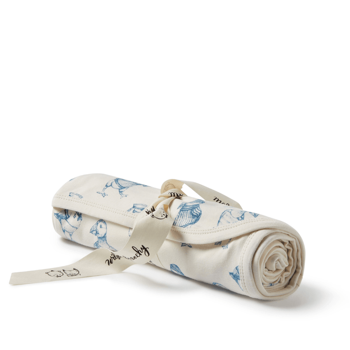 A blue and white Wilson & Frenchy Organic Baby Swaddle Blanket - LUCKY LAST - TROPICAL GARDEN ONLY with a ribbon on it.