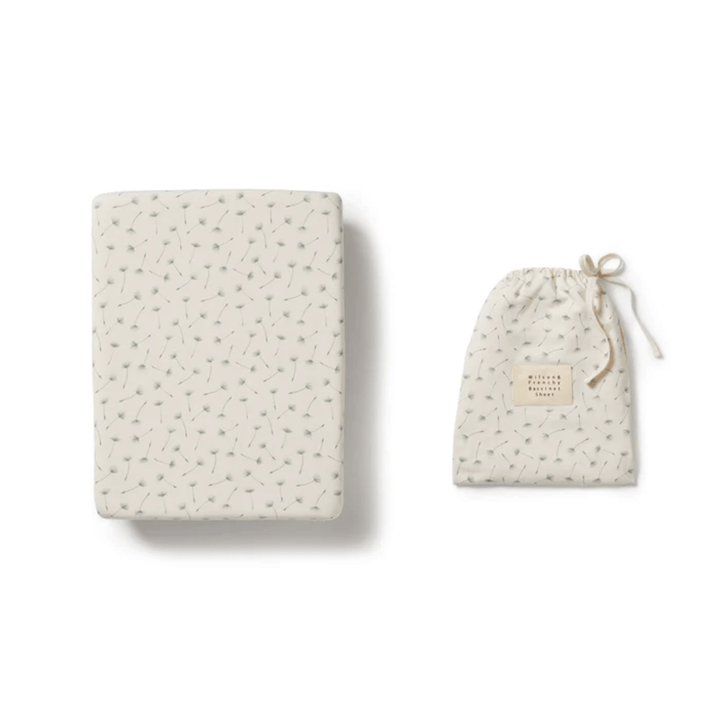 Wilson & Frenchy Lucky Last Hello Jungle Organic Cotton Bassinet Sheet next to a drawstring pouch with a similar design on a white background, both crafted from an organic cotton blend.