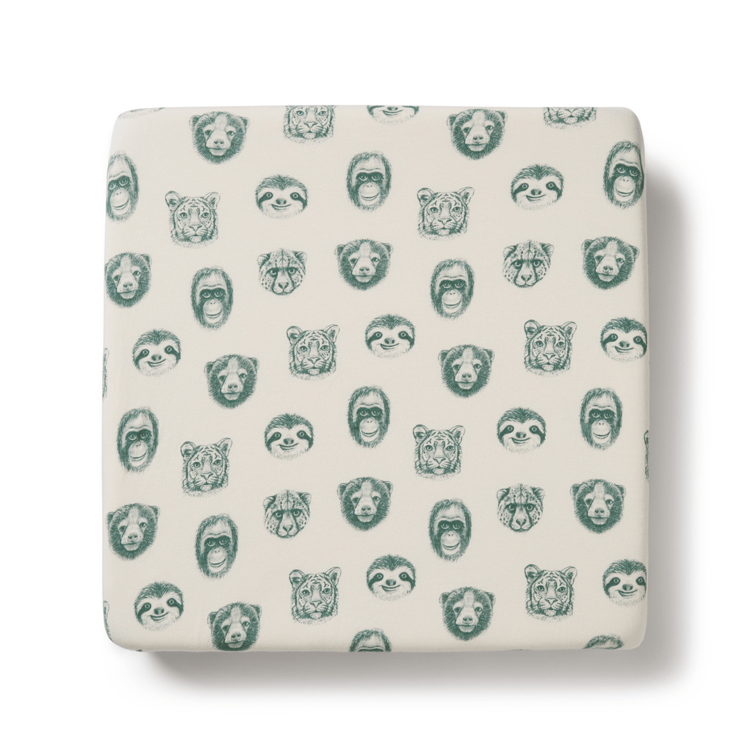A Wilson & Frenchy Organic Cotton Cot Sheet - LUCKY LASTS - FLOAT AWAY ONLY with green animal faces on it, ideal as a baby shower present.