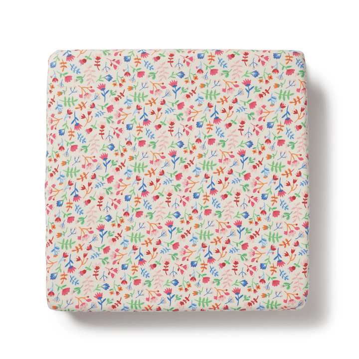 A small square Wilson & Frenchy Organic Cotton Cot Sheet - LUCKY LASTS - FLOAT AWAY ONLY with a floral pattern, perfect as a baby shower present or cot sheet.