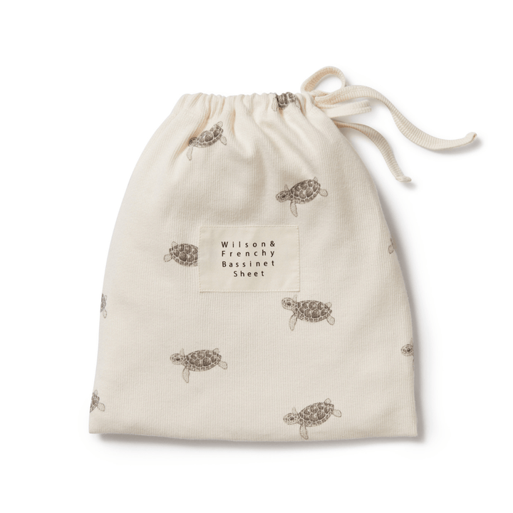 Fabric drawstring bag with turtle print, labeled "Wilson & Frenchy Organic Rib Bassinet Sheet - LUCKY LASTS - SHINE ON ME & SUMMER DAYS ONLY", available at OUTLET.