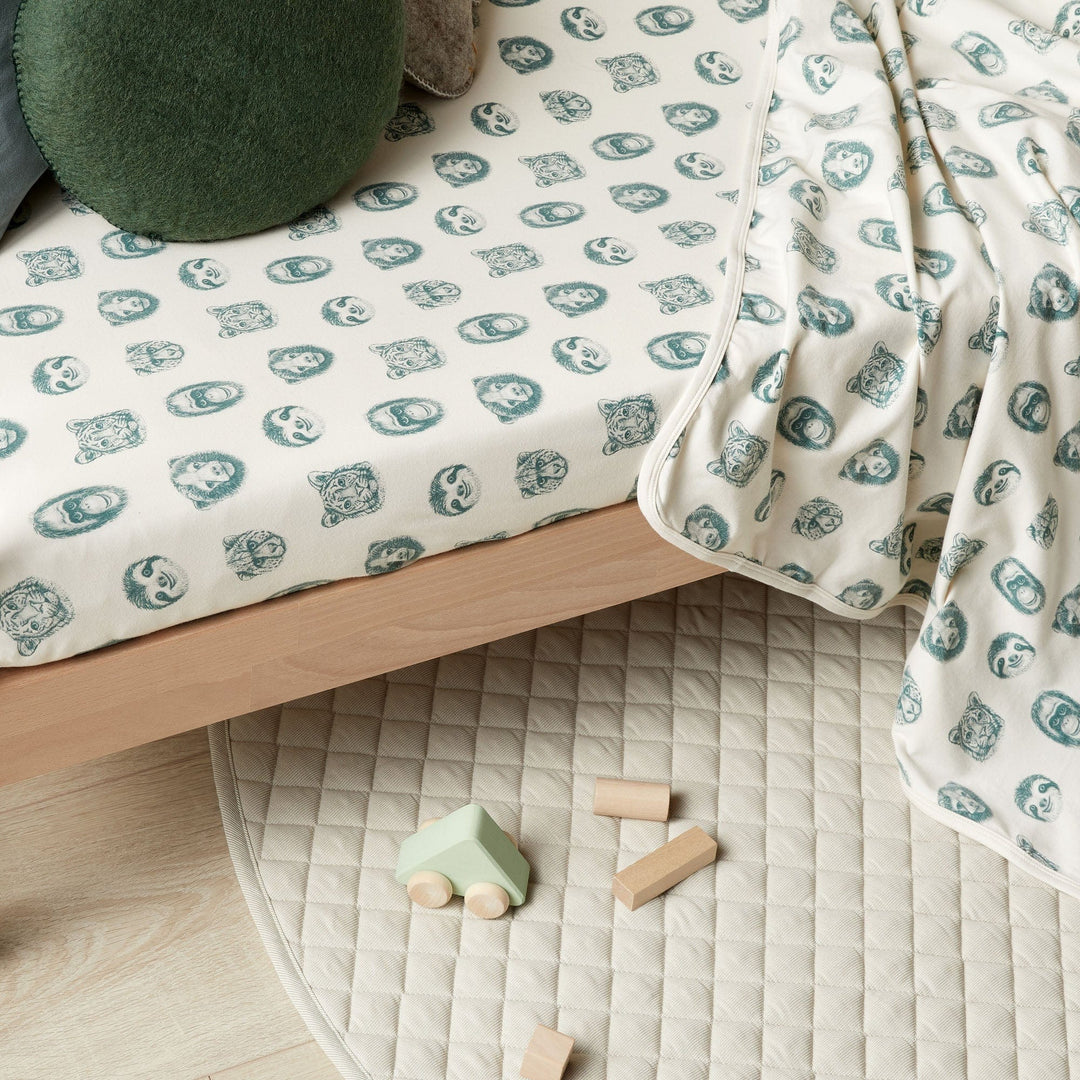A Wilson & Frenchy Organic Baby Swaddle Blanket - LUCKY LAST - TROPICAL GARDEN ONLY on a child's bed.