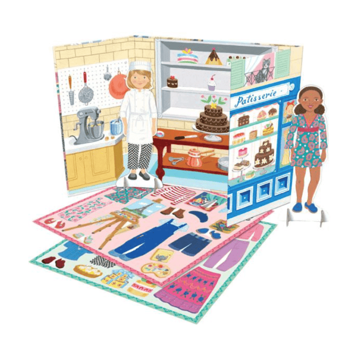 A girl is engaging in imaginative play with the eeBoo Paper Doll Sets (Multiple Variants) from eeBoo.