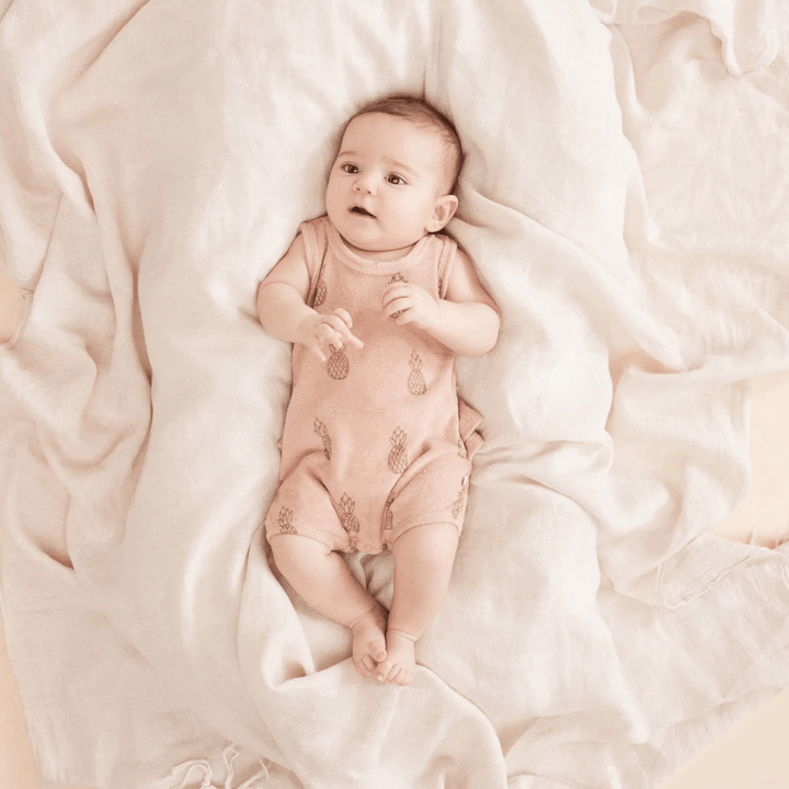 Adorable-Baby-Lyind-Down-Wearing-Wilson-and-Frenchy-Organic-Terry-Ruffle-Onesie-Pineapple-Naked-Baby-Eco-Boutique