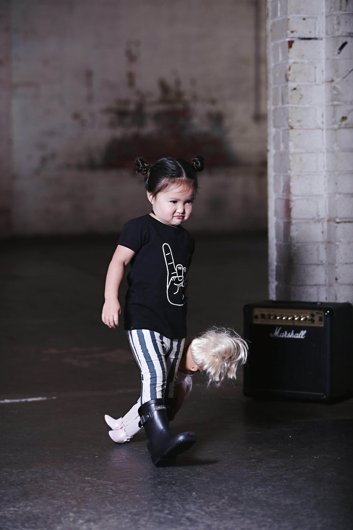 A little girl wearing an Anarkid Organic Cotton Slate Grunge Stripe Leggings - LUCKY LASTS - 0-3 MONTHS & 3-6 MONTHS made of organic cotton.