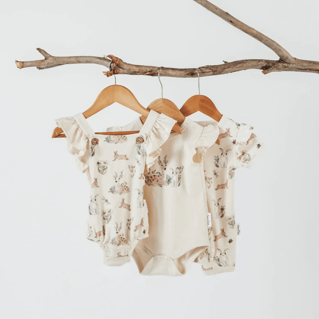 Aster-And-Oak-Organic-Cotton-Prairie-Print-Flutter-Onesie-Hanging-On-Tree-Branch-Naked-Baby-Eco-Boutique