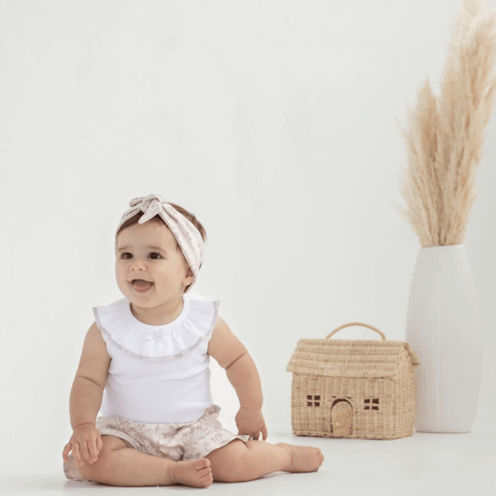 Baby-Girl-Smiling-Wearing-Aster-and-Oak-Organic-Ruffle-Bloomers-Fairy-Garden-Naked-Baby-Eco-Boutique