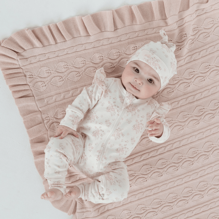 Baby-Laying-on-Blanket-Wearing-Baby-Sucking-Thumb-Wearing-Aster-and-Oak-Organic-Ruffle-Zip-Romper-Emmy-Floral-Naked-Baby-Eco-Boutique