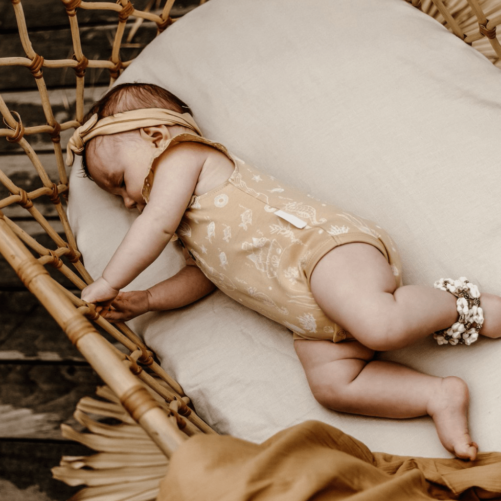 Baby-Laying-on-Side-Wearing-Aster-and-Oak-Organic-Mermaid-Lace-Henley-Onesie-Naked-Baby-Eco-Boutique