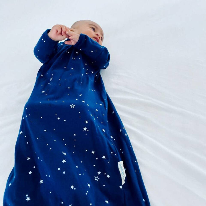 Baby-Lying-Down-Wearing-Woolbabe-Merino-and-Organic-Cotton-Sleeping-Gown-Tekapo-Stars-Naked-Baby-Eco-Boutique