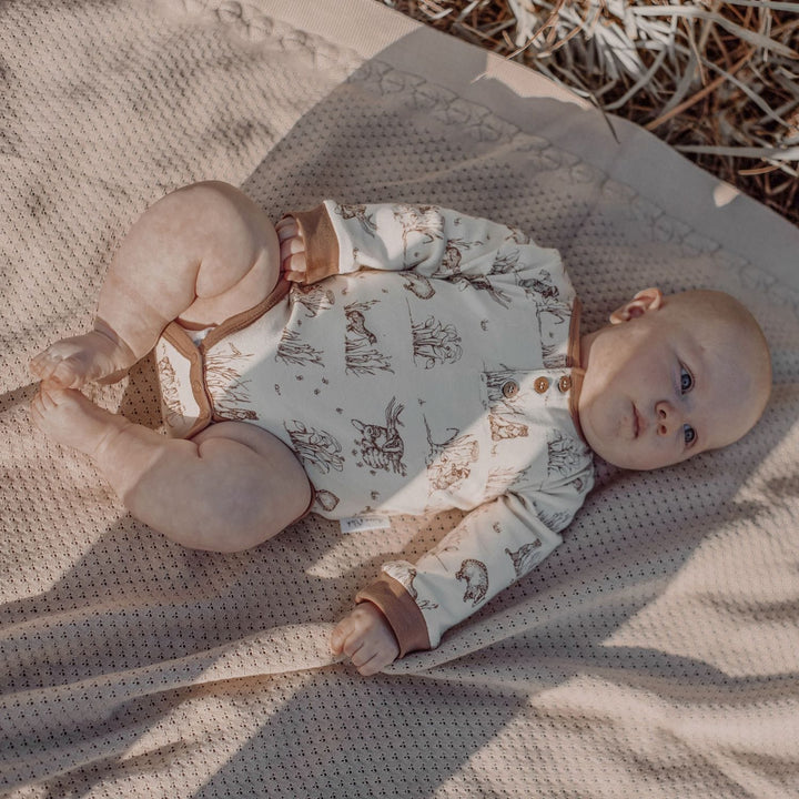 Baby-Lying-on-Blanket-Wearing-Aster-and-Oak-Organic-Cotton-AOP-Henley-Onesie-Badger-Naked-Baby-Eco-Boutique