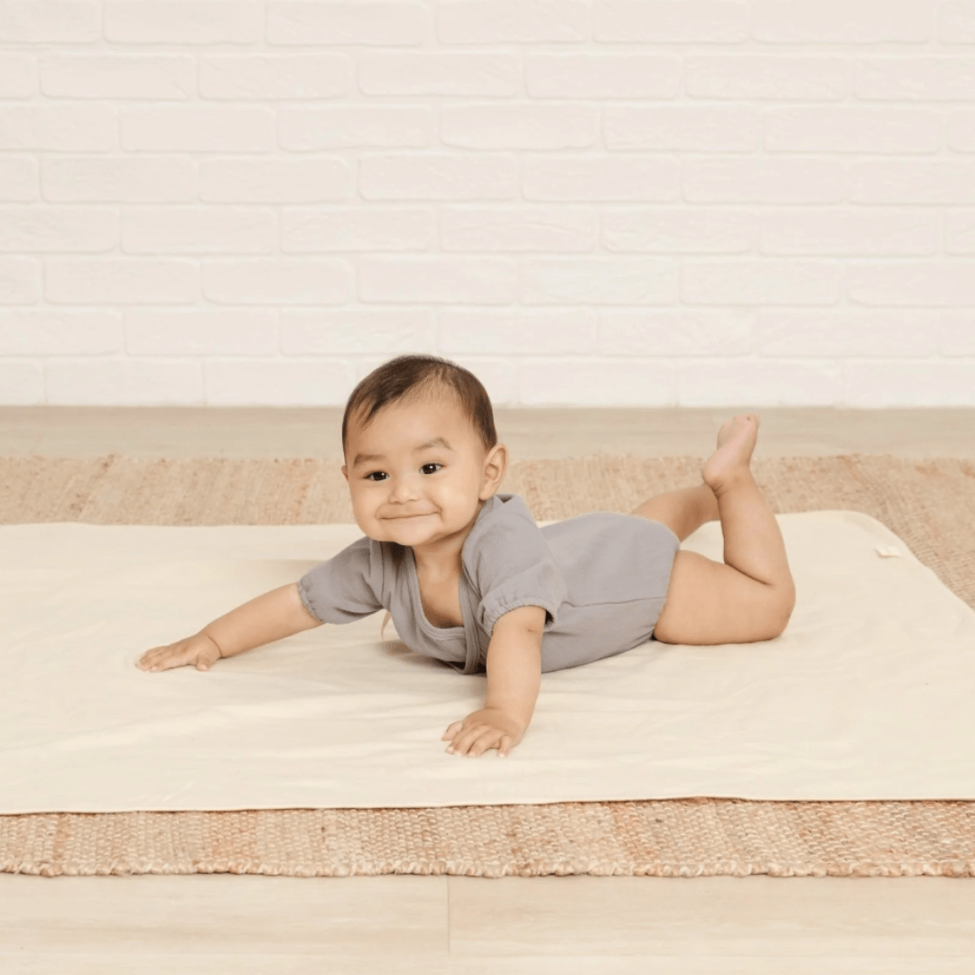 Baby-Lying-on-Tummy-Wearing-Quincy-Mae-Organic-Cotton-Woven-Wrap-Onesie-Washed-Indigo-Naked-Baby-Eco-Boutique