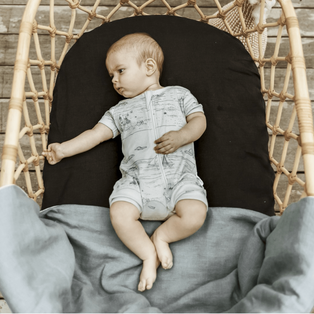 Baby-in-Bassinet-Wearing-Aster-and-Oak-Organic-Beach-Day-Zip-Romper-Naked-Baby-Eco-Boutique