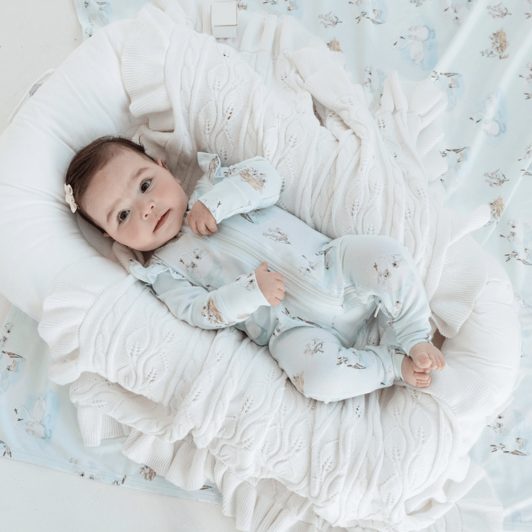Baby-in-Zipsuit-Lying-with-Aster-and-Oak-Organic-Cotton-Baby-Swaddle-Wrap-Swan-Naked-Baby-Eco-Boutique